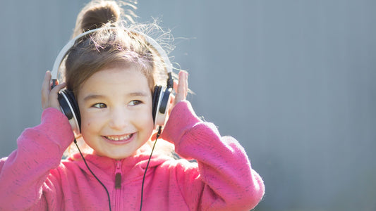 Young girl smiling while listening to music on headphones