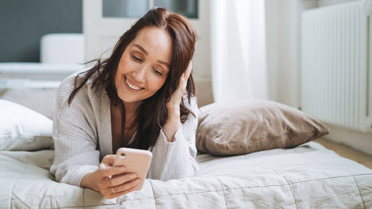 Woman checking phone in bed